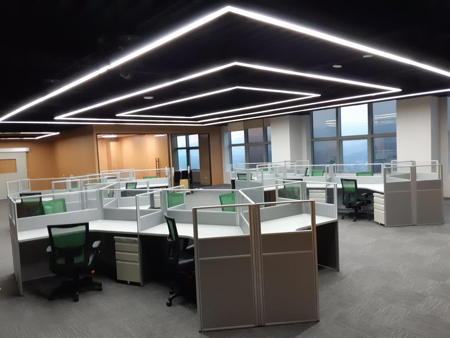 協洋 2.5 屏風開放辦公區 120 度 V 型桌板搭配綠色辦公椅與城市景觀